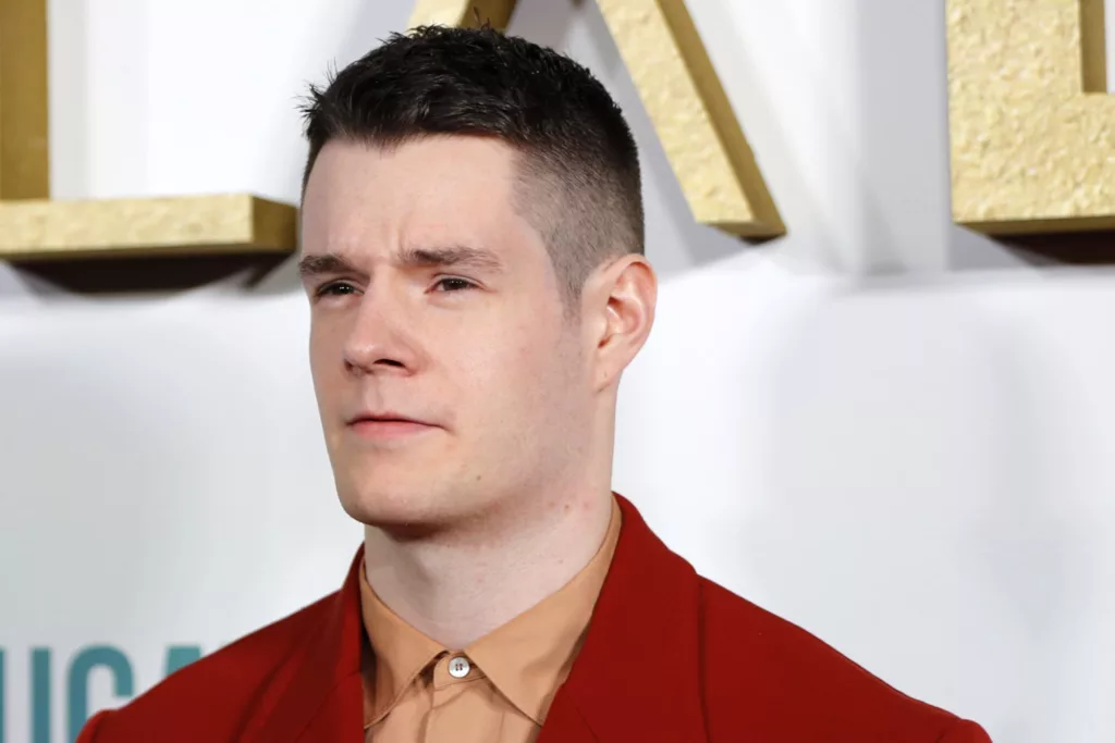 Picture of actor Connor Swindells in red suit